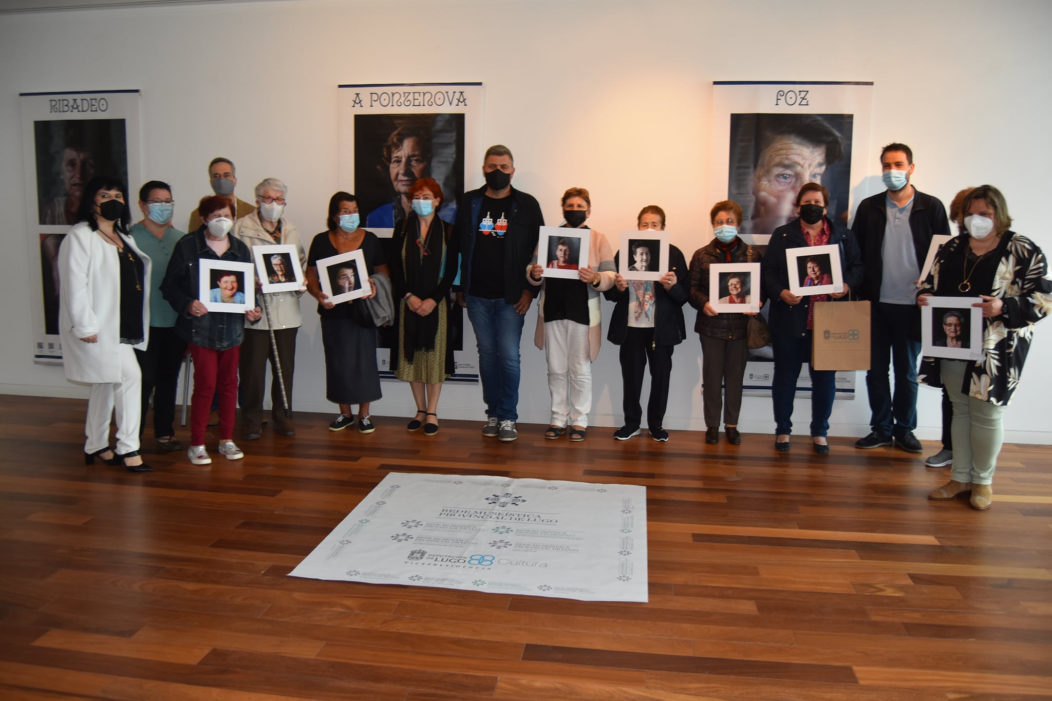Maite Ferreiro xunto ás mulleres homenaxeadas na inauguración da mostra: Inés Fraga Naray “Sita” de Foz, Dora Tallón Maseda de Alfoz, Tarsila Veiga Vega de Barreiros, María Jesús Alonso López de Burela, Bárbara Gil García de Ourol, María del Carmen Río de Ribadeo, Josefa Meitín de Xove e Hortensia García Freije de Riotorto