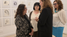Encarna Lago, Aurelia Balseiro e Iria Castro conversan con Concha Mayordomo diante das obras da exposición “500 mulleres na arte”